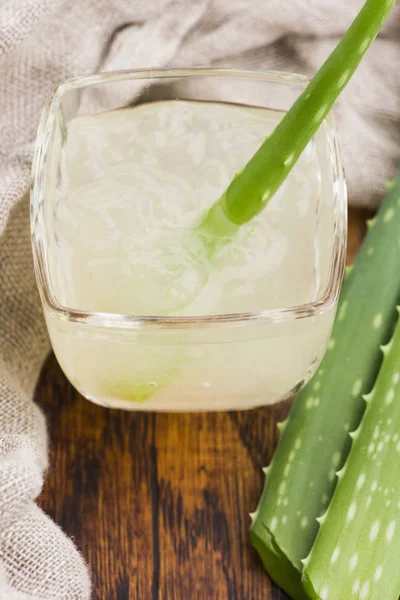 Louça de vidro com suco de aloe vera fresco e folhas — Fotografia de Stock