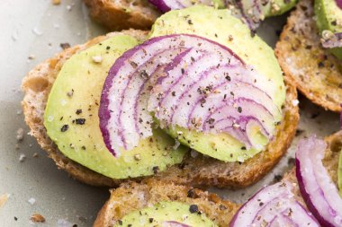 Taze avokado ve soğanlı sandviç.