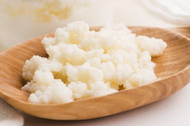 Kaşık içinde sütlü kefir taneleri. Maya bakteriyel fermantasyon başlatıcı