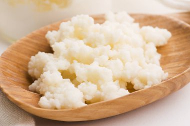 Kaşık içinde sütlü kefir taneleri. Maya bakteriyel fermantasyon başlatıcı