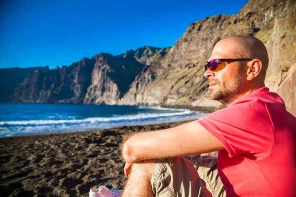 ชายในแว่นตากันแดดเพลิดเพลินกับชายหาดที่สวยงาม Playa de los Guios — ภาพถ่ายสต็อก
