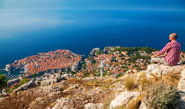 Turista mirando hacia abajo a la hermosa ciudad de Dubrovnik — Foto de Stock