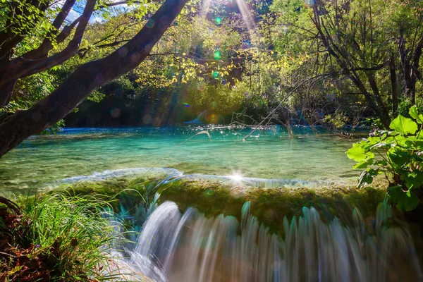 Kleiner Wasserfall mit Sonnenstrahlen — Stockfoto