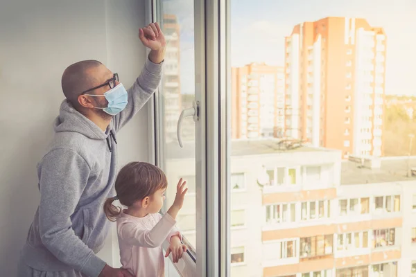 Чоловік Медичній Масці Його Маленька Дочка Дивляться Через Вікно Залишайся — стокове фото