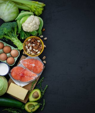 Flexitarian diyeti, keto diyeti. Sağlıklı dengeli gıdaların ürünleri. Yeşil sebze, avokado, fındık, somon, yumurta, süt ürünleri. Sağlıklı gıda konsepti. Siyah arkaplan, üst görünüm, kopyalama alanı