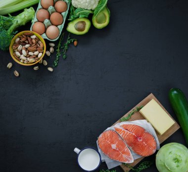 Flexitarian diyeti, keto diyeti. Sağlıklı dengeli gıdaların ürünleri. Yeşil sebze, avokado, fındık, somon, yumurta, süt ürünleri. Sağlıklı gıda konsepti. Siyah arkaplan, üst görünüm, kopyalama alanı
