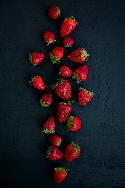 Siyah arka planda taze kırmızı çilekler, üst manzara.