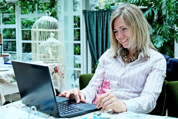 Vacker blond kvinna med en bärbar dator — Stockfoto