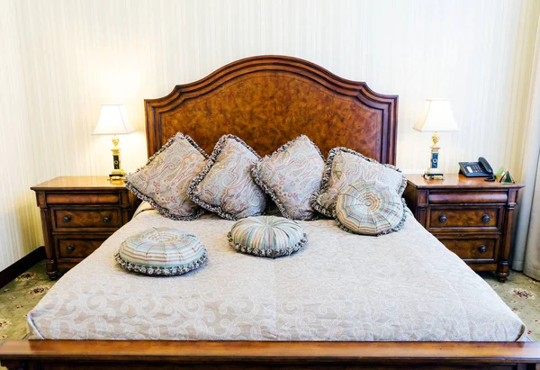 Двуспальная кровать с подушками в роскошной спальне — стоковое фото