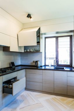 Beyaz duvarları ve ahşap zemini olan modern mutfak.. 