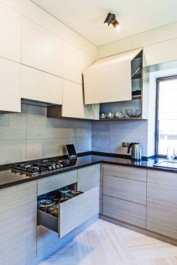 Beyaz duvarları ve ahşap zemini olan modern mutfak.. 