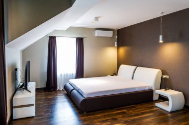 Rahat bir yatağı olan bir otel odası. 