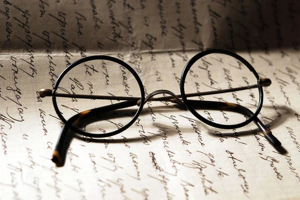 Old glasses on a letter — Stock Photo, Image