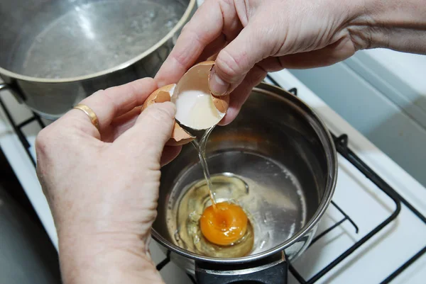 Bir yumurta kırma eller. Çiğ yumurta kasenin içine dökülen. Anahtar madde f