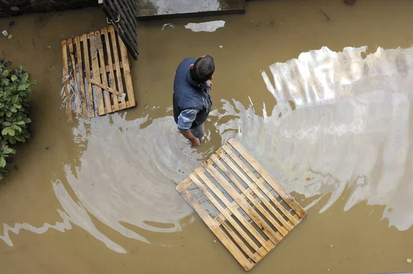 Las consecuencias de las inundaciones, el hombre en el agua ayudando a los vecinos — Foto de Stock