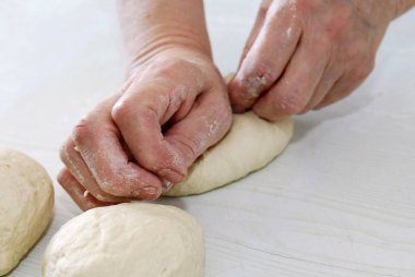 Kadın bir tabloda hamur unrolls 