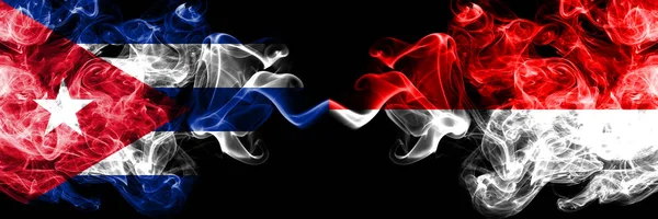 Κούβα, Κούβα εναντίον Ινδονησίας, Ινδονησία καπνιστή μυστικιστική σημαίες τοποθετούνται δίπλα-δίπλα. Χοντρά χρωματιστά μεταξένια ταξίδια αφηρημένα καπνίζει πανό. — Φωτογραφία Αρχείου
