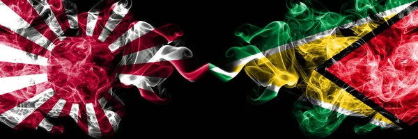 Japan rising sun naval vs Guyana, Guyanese smoky mystic flags placed side by side. Thick colored silky travel abstract smokes banners — Stock Fotó