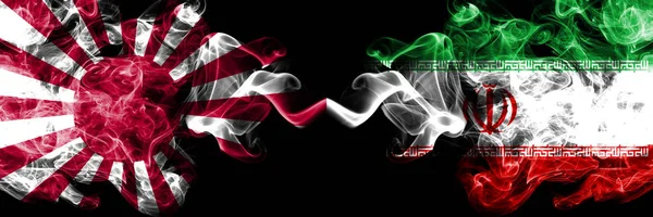 Japão nascente sol naval vs Irã, bandeiras místicas fumegantes iranianas colocadas lado a lado. Grosso colorido viagem sedosa abstrato fuma banners — Fotografia de Stock