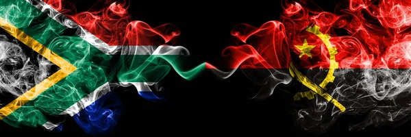 Dél-Afrika vs Angola, Angolai füstös misztikus zászlók egymás mellett. Vastag színű selymes elvont füst zászlók koncepció — Stock Fotó