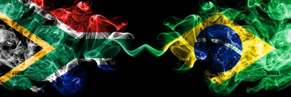 Zuid-Afrika vs Brazilië, Braziliaanse rokerige mystieke vlaggen naast elkaar geplaatst. Dikke gekleurde zijdeachtige abstracte rook vlaggen concept — Stockfoto