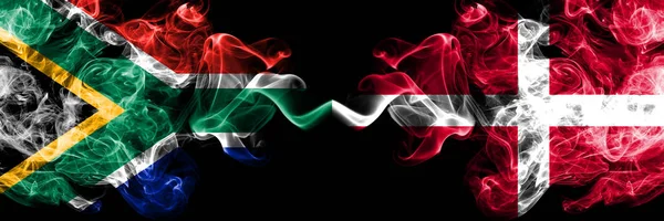 South Africa vs Denmark, Danish smoky mystic flags placed side by side. Thick colored silky abstract smoke flags concept — Stock Photo, Image