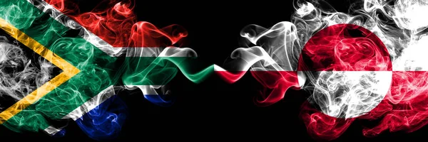 Zuid-Afrika vs Groenland rokerige mystieke vlaggen naast elkaar geplaatst. Dikke gekleurde zijdeachtige abstracte rook vlaggen concept — Stockfoto