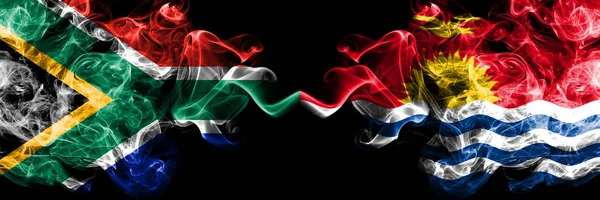 Zuid-Afrika vs Kiribati rokerige mystieke vlaggen naast elkaar geplaatst. Dikke gekleurde zijdeachtige abstracte rook vlaggen concept — Stockfoto