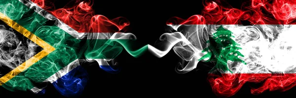 Zuid-Afrika vs Libanon, Libanese rokerige mystieke vlaggen naast elkaar geplaatst. Dikke gekleurde zijdeachtige abstracte rook vlaggen concept — Stockfoto