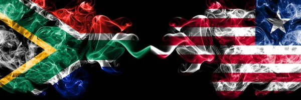 Dél-Afrika vs Libéria, libériai füstös misztikus zászlók egymás mellett. Vastag színű selymes elvont füst zászlók koncepció — Stock Fotó