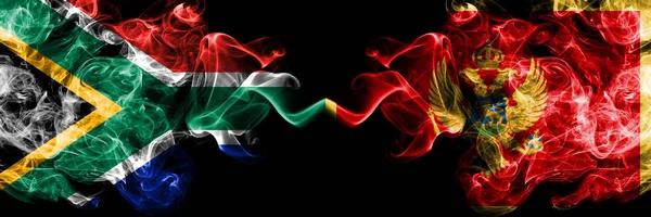 Güney Afrika Karadağ 'a karşı, Karadağ' ın dumanlı mistik bayrakları yan yana yerleştirildi. Kalın renkli ipeksi soyut duman bayrakları konsepti — Stok fotoğraf