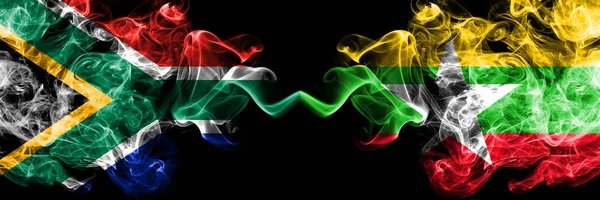 Zuid-Afrika vs Myanmar rokerige mystieke vlaggen naast elkaar geplaatst. Dikke gekleurde zijdeachtige abstracte rook vlaggen concept — Stockfoto