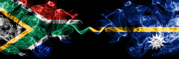 Zuid-Afrika vs Nauru rokerige mystieke vlaggen naast elkaar geplaatst. Dikke gekleurde zijdeachtige abstracte rook vlaggen concept — Stockfoto