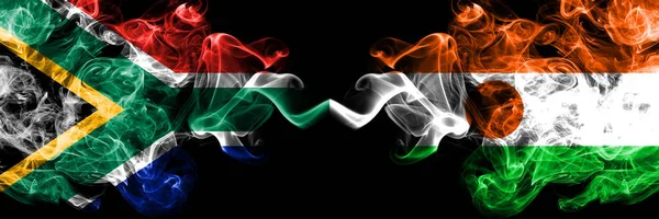 Dél-Afrika vs Niger, nigériai füstös misztikus zászlók egymás mellett. Vastag színű selymes elvont füst zászlók koncepció — Stock Fotó