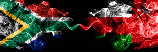 Zuid-Afrika vs Oman, Omani rokerige mystieke vlaggen naast elkaar geplaatst. Dikke gekleurde zijdeachtige abstracte rook vlaggen concept — Stockfoto