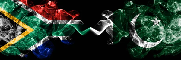 Zuid-Afrika vs Pakistan, Pakistaanse rokerige mystieke vlaggen naast elkaar geplaatst. Dikke gekleurde zijdeachtige abstracte rook vlaggen concept — Stockfoto