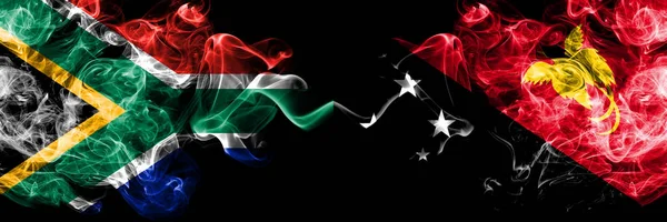 Zuid-Afrika vs Papoea-Nieuw-Guinea rokerige mystieke vlaggen naast elkaar geplaatst. Dikke gekleurde zijdeachtige abstracte rook vlaggen concept — Stockfoto