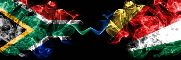 Zuid-Afrika vs Seychellen, Seychelloise rokerige mystieke vlaggen naast elkaar geplaatst. Dikke gekleurde zijdeachtige abstracte rook vlaggen concept — Stockfoto