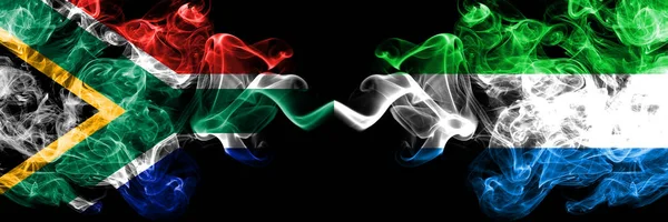 Sudafrica vs Sierra Leone bandiere mistiche fumose affiancate. Concetto di bandiere di fumo astratte di seta colorate spesse — Foto Stock