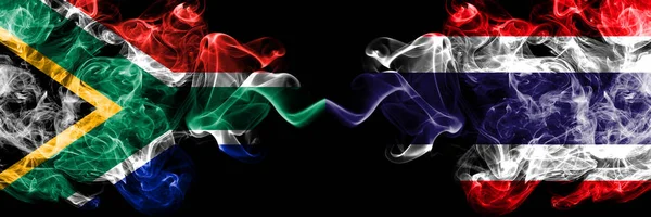 Южная Африка против Таиланда, тайские дымчатые мистические флаги, размещенные бок о бок. Толстые цветные шелковистые абстрактные флаги — стоковое фото