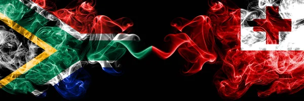 Zuid-Afrika vs Tonga, Tongan rokerige mystieke vlaggen naast elkaar geplaatst. Dikke gekleurde zijdeachtige abstracte rook vlaggen concept — Stockfoto