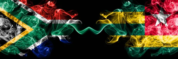 Dél-Afrika vs Togo, Togói füstös misztikus zászlók egymás mellett. Vastag színű selymes elvont füst zászlók koncepció — Stock Fotó