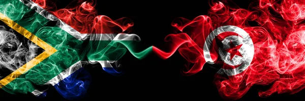 Zuid-Afrika vs Tunesië, Tunesische rokerige mystieke vlaggen naast elkaar geplaatst. Dikke gekleurde zijdeachtige abstracte rook vlaggen concept — Stockfoto