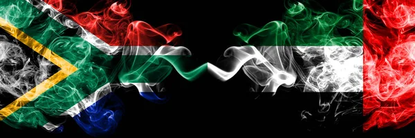 Republika Południowej Afryki vs Zjednoczone Emiraty Arabskie, Emirati smoky mistyczne flagi umieszczone obok siebie. Gruba, jedwabista, abstrakcyjna koncepcja flag dymnych — Zdjęcie stockowe