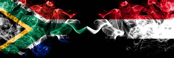Dél-Afrika vs Jemen, jemeni füstös misztikus zászlók egymás mellett. Vastag színű selymes elvont füst zászlók koncepció — Stock Fotó