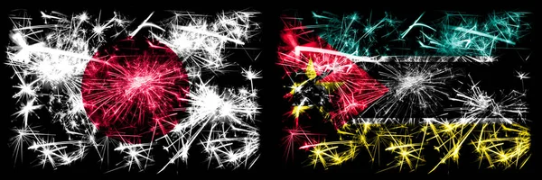 Japonsko, Japonsko vs Mosambik, Mosambik Nový rok oslavy jiskřivé ohňostroje vlajky koncept pozadí. Kombinace dvou abstraktních stavových příznaků — Stock fotografie