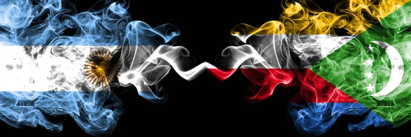 Argentina vs Komorerna, Komoriska rökiga mystiska brandflaggor placerade sida vid sida. Tjock färgad silkeslen abstrakt rök flaggor koncept — Stockfoto