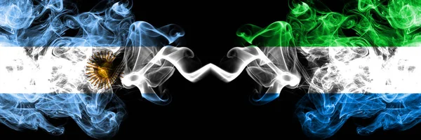 Argentina vs Sierra Leone smoky mystic fire flags placed side by side. Thick colored silky abstract smoke flags concept — Stock Photo, Image