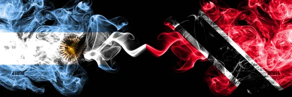 Argentina vs Trinidad y Tobago banderas de fuego místicas ahumadas colocadas una al lado de la otra. concepto de banderas de humo abstracto sedoso de color grueso — Foto de Stock
