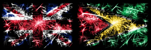 イギリス、イギリス対ガイアナ、ガイアナの新年のお祝い旅行輝く花火の旗のコンセプトの背景。2つの抽象的な状態フラグの組み合わせ. — ストック写真